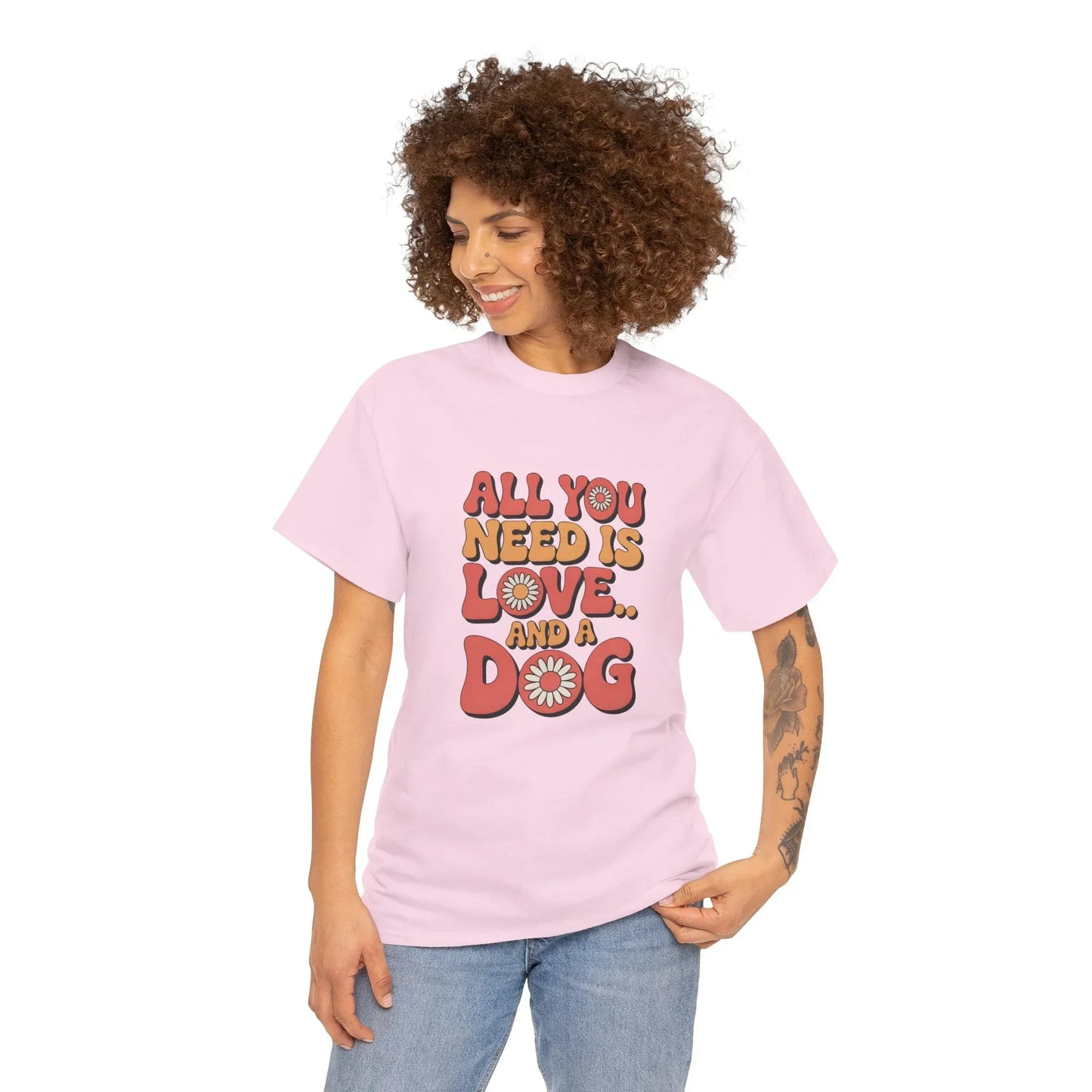 Woman in light pink t-shirt with 'All you need is love and a dog' retro text and daisy graphics