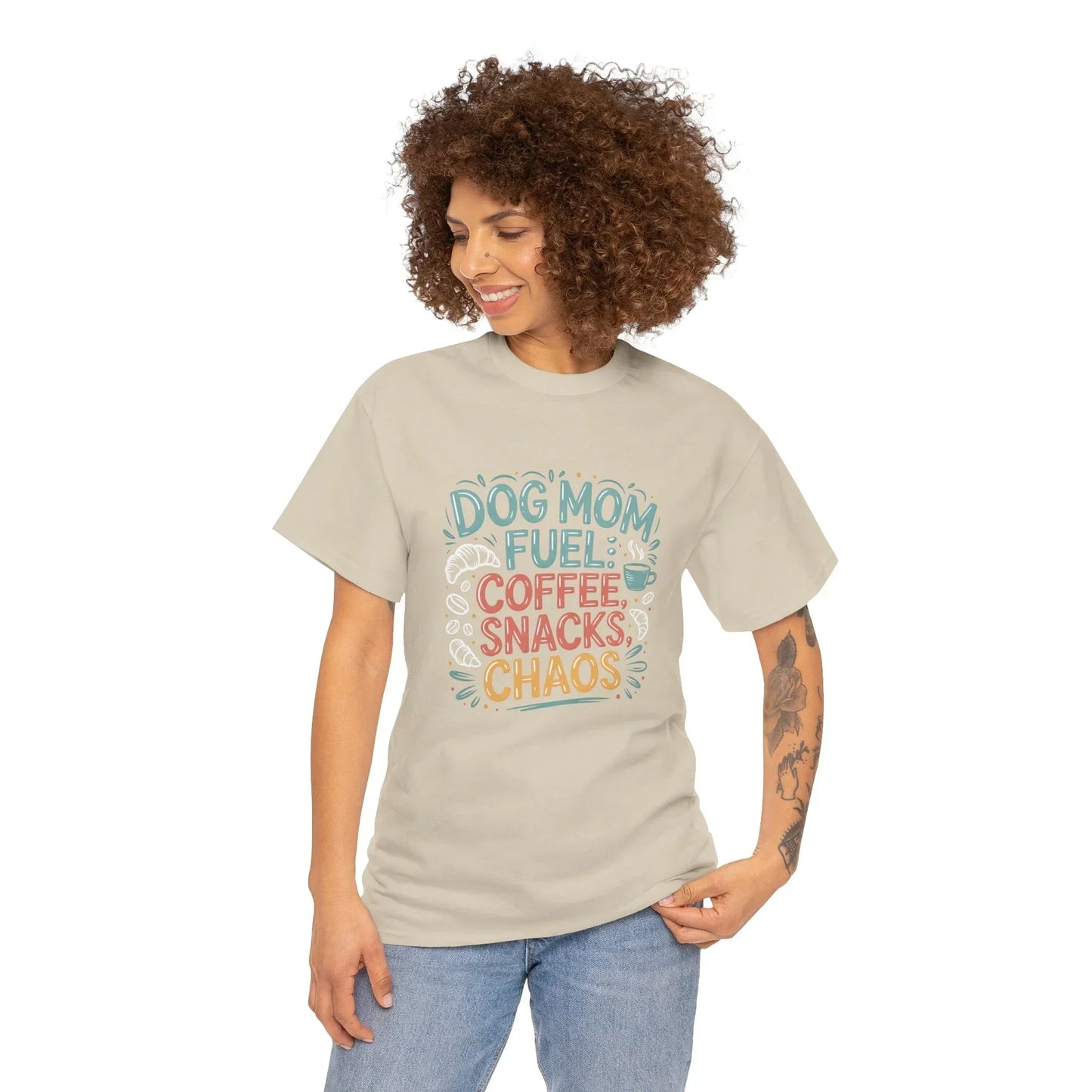 Woman wearing beige Dog Mom Fuel t-shirt with coffee, snacks, chaos graphic design
