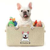 French bulldog in beige pet storage box with dog toys and cartoon dog print on front