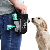 Dog treat pouch with waste bag dispenser attached to person, golden retriever nearby